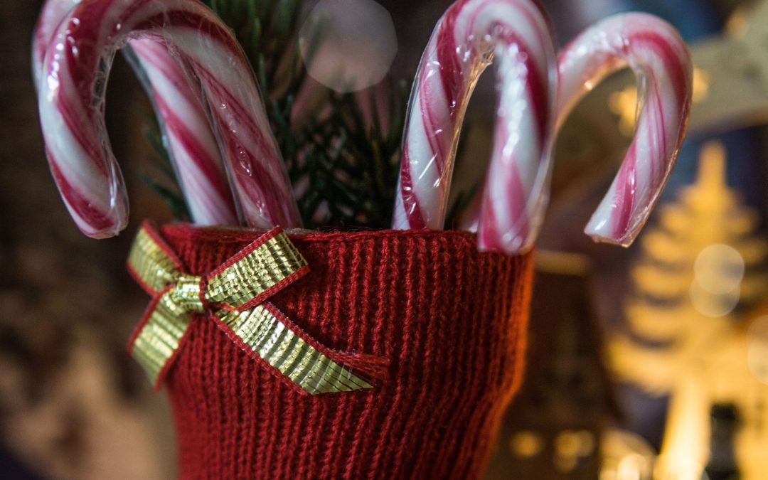 Roter Strickstiefel mit Zuckerstangen und Tannenzweigen