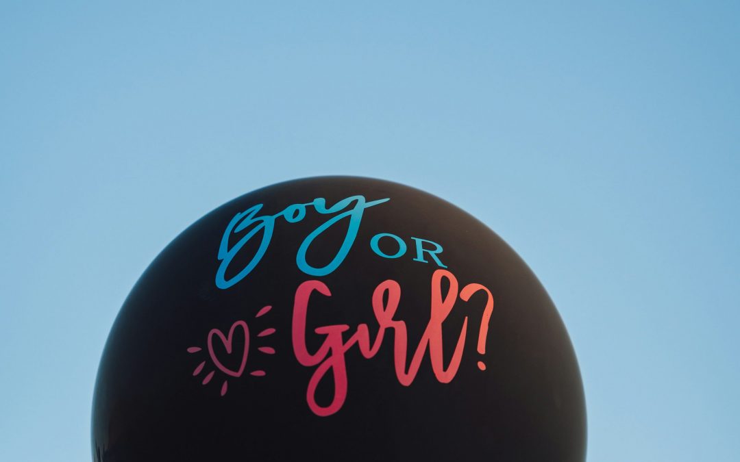 Schwarzer Luftballon mit der Aufschrift Boy or Girl vor blauem Himmel