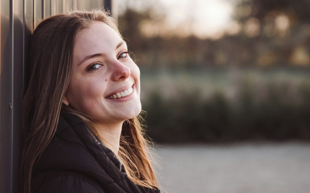 Junge Frau lächelt im Freien, Abendlicht