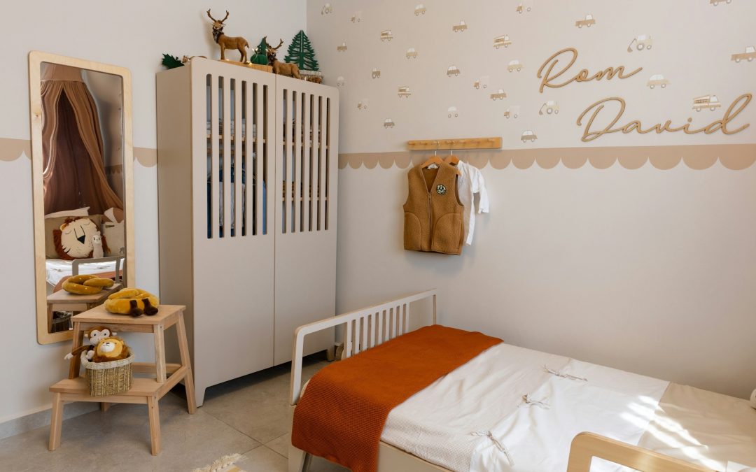 Helles Kinderzimmer mit weissem Einzelbett, oranger Decke, Schrank und Spiegel in warmen Farben