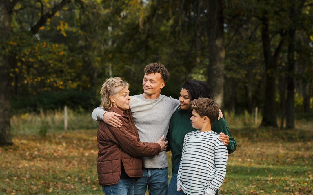 Eine Familie steht im Herbstlicht eng beieinander und hält sich fest